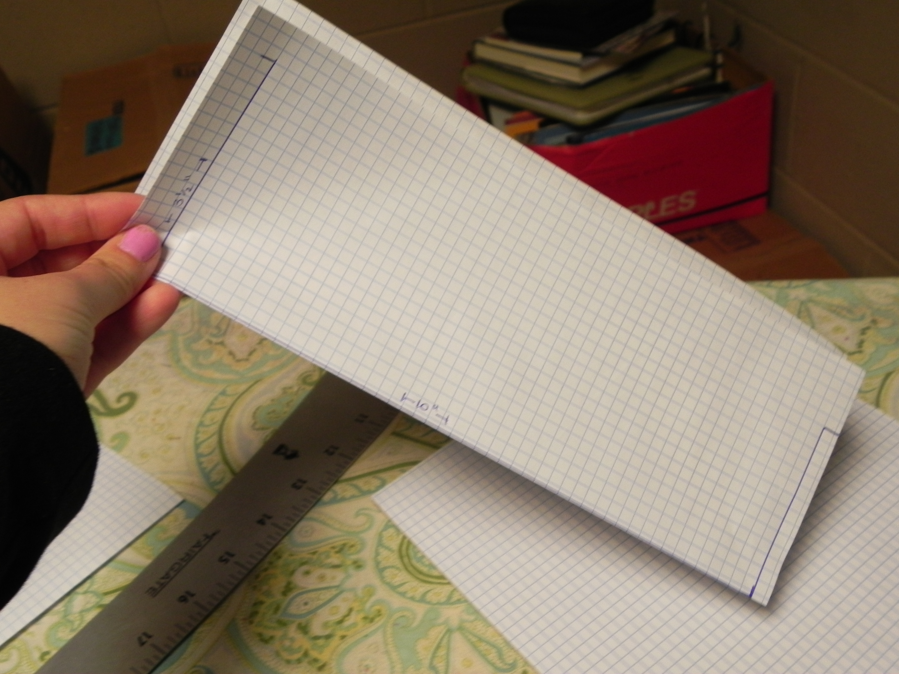Folding the graph paper in half to make equal sides. 