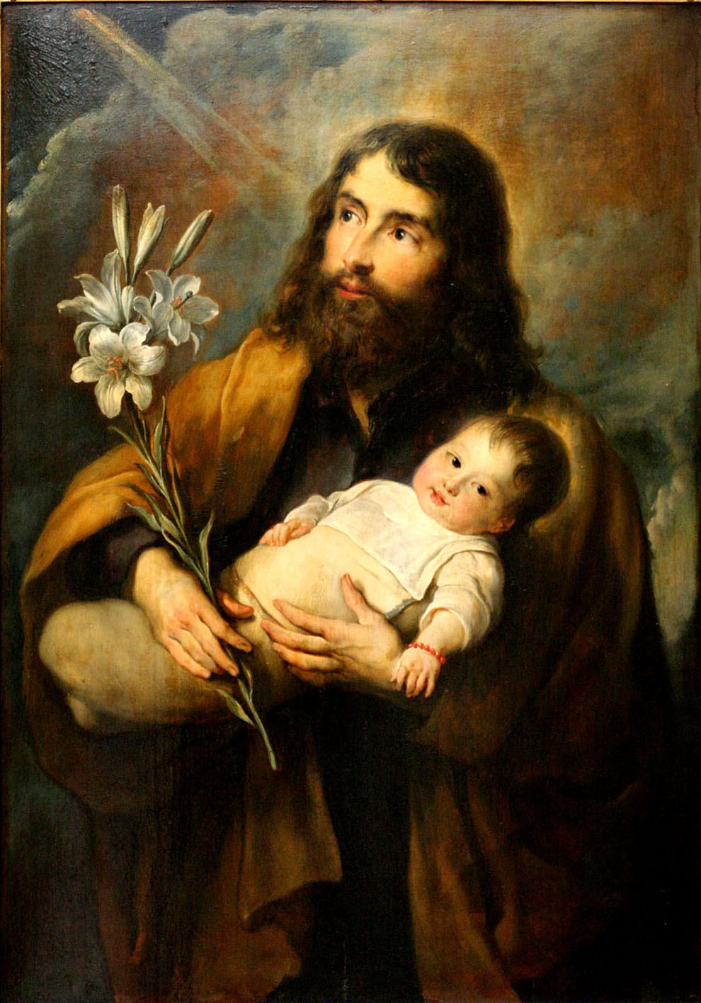 Painting of Joseph holding baby Jesus with a red bracelet and a sprig of white Lillies. 