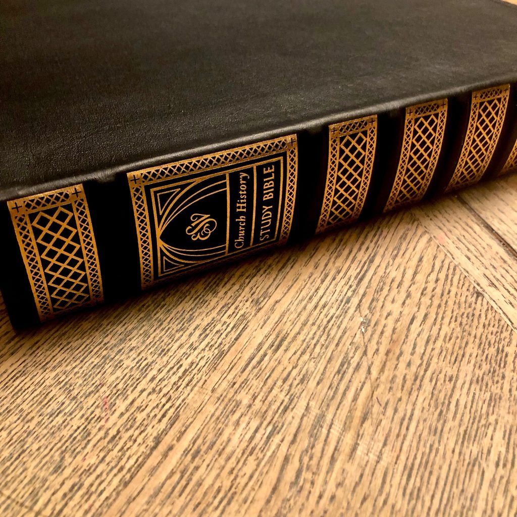 Angled view of the gilded spine of the ESV Church History Study Bible on wood table