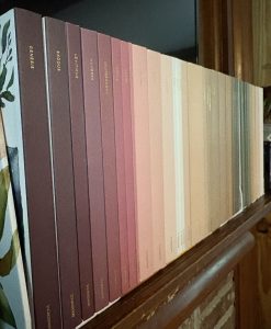 Set of many books in a line on wooden mantle. 